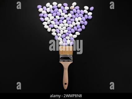 Top view of white and purple easter eggs, paint brush on black background. Creative easter composition, spring, flat lay, copy space. Stock Photo