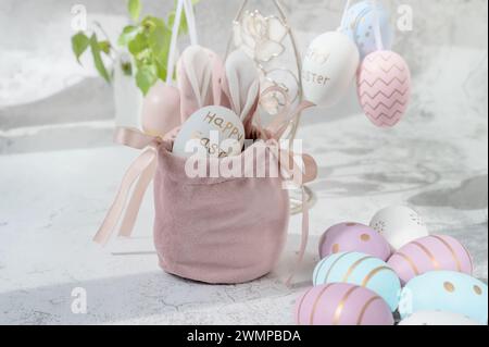 Spring Easter still life. Painted eggs in a silk decorative bag with bunny ears. Easter decor on the table. Stock Photo