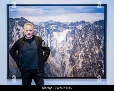 London, UK. 27th Feb, 2024. The artist with Coast Mountains #15, Receding of Glacier, British Columbia, Canada, 2023 - Edward Burtynsky, New Works, a solo exhibition at Flowers Gallery, London. This coincides with the Saatchi Gallery retrospective. This exhibition runs from 27 February-6 April 2024. Credit: Guy Bell/Alamy Live News Stock Photo