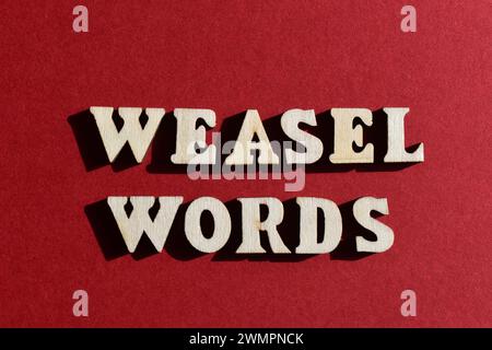 Weasel Words, phrase in wooden alphabet letters isolated on red background Stock Photo