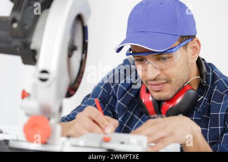 workman cutting wooden planks using circular saw in workshop Stock Photo