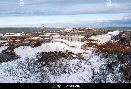 A bear guard watches over tourists visiting the historic fortification sites at Cape Merry in Churchill, Manitoba, Canada Stock Photo