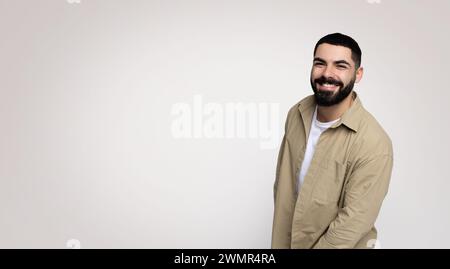 A jovial man with a beard and a wide smile leans slightly towards the camera Stock Photo