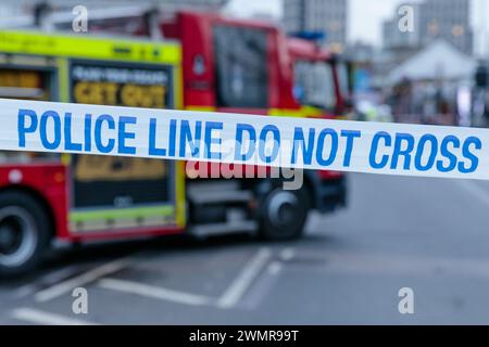 Blue and White POLICE LINE DO NOT CROSS cordon tape with a Fire Engine in the background at the scene of a fire in the UK.  Photo by Amanda Rose/Alamy Stock Photo