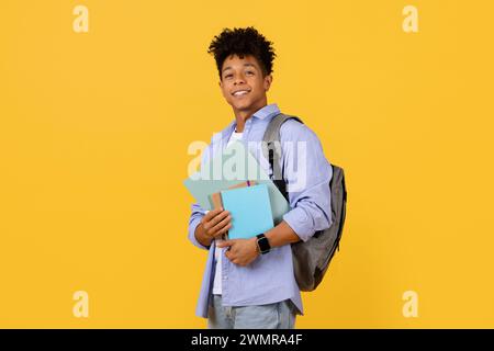 Smiling black student guy with backpack holding books Stock Photo