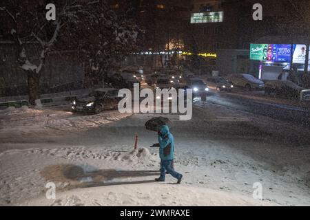 Teheran, Iran. 27th Feb, 2024. Passers-by are walking on a street in Tehran. The capital is snowed in after heavy snowfall. There is chaos on the streets and many people are abandoning their cars and walking home. Iran's national gas company has called on people to save energy due to possible shortages. Credit: Arne Bänsch/dpa/Alamy Live News Stock Photo