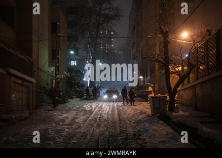 Teheran, Iran. 27th Feb, 2024. A driver drives slowly on a snow-covered road. The capital is snowed in after heavy snowfalls. There is chaos on the streets and many people are abandoning their cars and walking home. Iran's national gas company has called on people to save energy due to possible shortages. Credit: Arne Bänsch/dpa/Alamy Live News Stock Photo