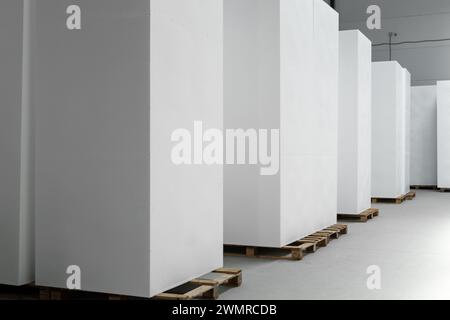 A large blocks of Styrofoam are stacked in a warehouse. Industrial production of polystyrene foam insulation panels or plates from expanded polystyren Stock Photo