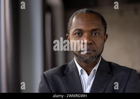 Close-up of a contemplative African American businessman in a suit, exuding professionalism and determination. Stock Photo