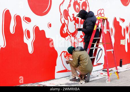 Commercial artists hand painting an advertisement on a wall in New York City. Stock Photo
