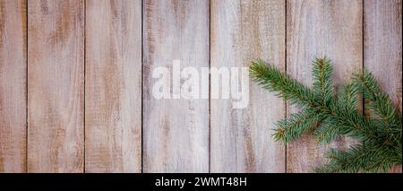 Christmas winter banner with a snow-covered Christmas tree branch on an old shabby table. Light winter banner for advertising, congratulations or sale Stock Photo