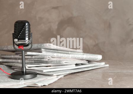 Newspapers and vintage microphone on marble table. Journalist's work Stock Photo