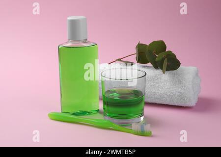 Composition with fresh mouthwash in bottle, glass and toothbrush on pink background, closeup Stock Photo
