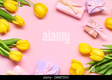 Gift boxes and yellow tulips on pink background Stock Photo