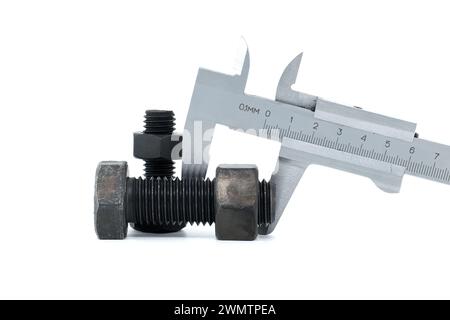 Caliper measure two adjacent black bolts with hexagonal heads, lying on a white background Stock Photo