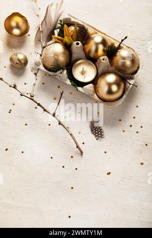 Stylish golden eggs easter concept. Easter gold eggs with flowers on light background. Happy easter card. Top view. Copy space. Stock Photo