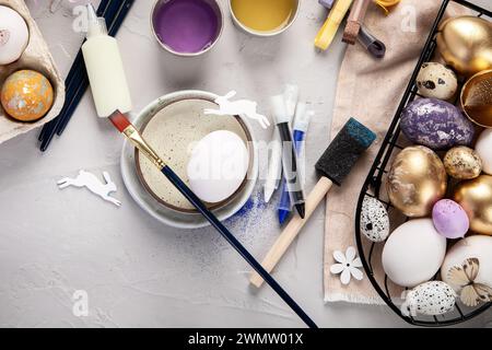 Happy Easter, painting eggs. Paints, pens, decorations for coloring eggs for holiday on a white background.. Top view. Stock Photo