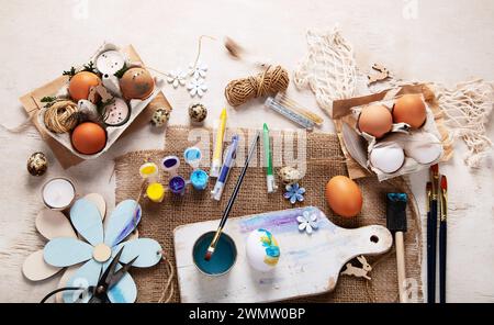 Happy Easter, painting eggs. Paints, pens, decorations for coloring eggs for holiday on a white background. Top view. Stock Photo
