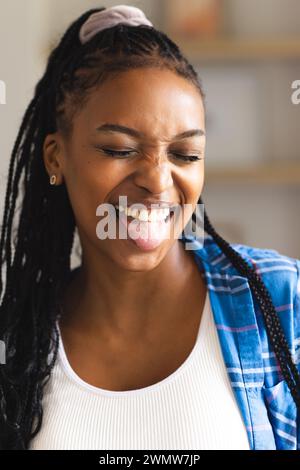 Young African American woman laughs joyfully, sticking out her tongue playfully Stock Photo