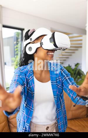 Young African American woman explores virtual reality, wearing a VR headset Stock Photo