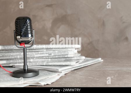 Newspapers and vintage microphone on marble table. Journalist's work Stock Photo