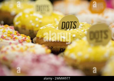 A bunch of colorful doughnuts with labels on them Stock Photo