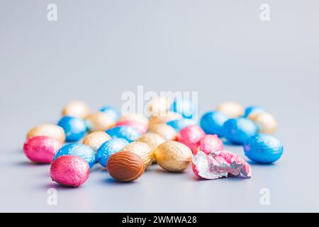 Easter chocolate eggs wrapped in aluminium foil on the gray background. Stock Photo