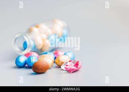 Easter chocolate eggs wrapped in aluminium foil on the gray background. Stock Photo