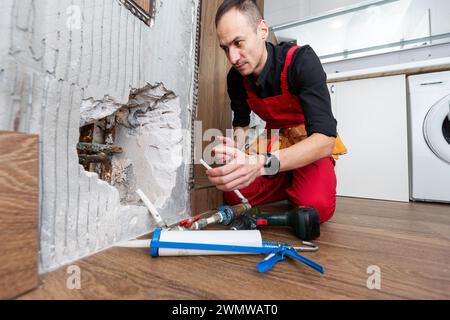 Construction man using hammer and tool while demolish wall Stock Photo