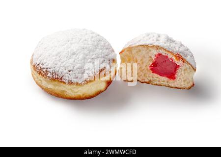Tempting fluffy freshly baked doughnuts with aromatic strawberry filling, topped with powdered sugar, isolated on white background. Traditional sweets Stock Photo