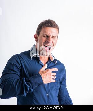 A man contorting his face humorously with his hands, creating a comical expression. His hands are positioned in a playful manner, contributing to the humorous gesture. Stock Photo