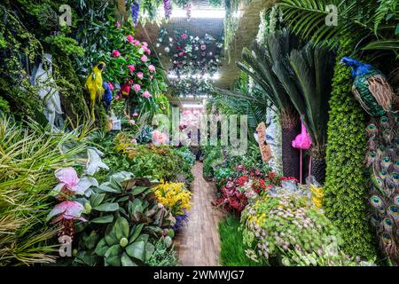 A view inside a shop that sells artificial, plastic, fake plants, flowers, birds, ferns. At the Barakholka shipping container local market in Almaty, Stock Photo