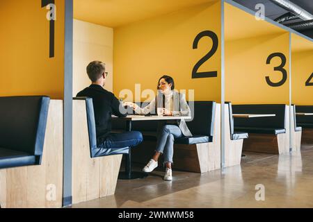 A diverse group of professionals collaborating in a modern office space. Business men and women, designers, developers, and engineers engage in conver Stock Photo