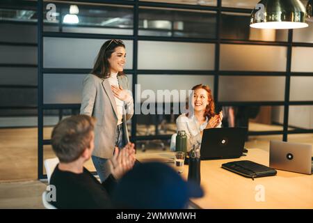 Group of business professionals in a boardroom discussing ideas. They applaud, smile, and demonstrate successful teamwork. This dynamic scene showcase Stock Photo