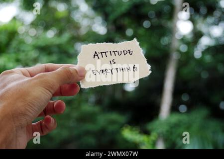 attitude is everything - Hand holding torn paper motivational slogan Inspirational Typography Quote on torn paper Stock Photo