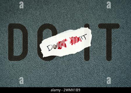 Changing the words Don't Quit to Do It with red pen in a motivational message about hope and perseverance. Stock Photo