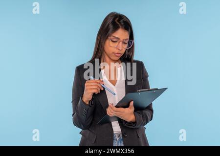 serious business Indian woman manager with documents on a blue background working in a financial company success Stock Photo