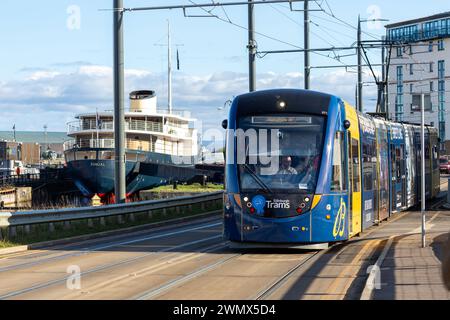 A tram on Ocean Drive heading to Newhaven with the Fingal Luxury hotel in the background, Leith, Edinburgh Stock Photo