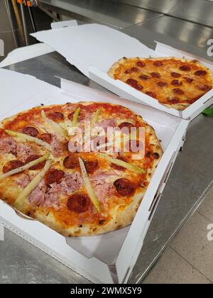 Two pizzas in boxes on a counter with handles, ready for delivery Stock Photo