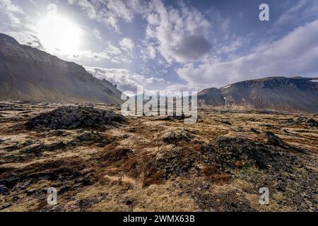 An Icelandic landscape featuring brown hills under a blue sky with fluffy clouds Stock Photo