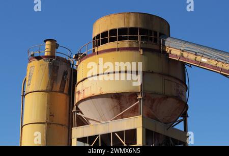Amidst an urban landscape, the remnants of an old abandoned factory stand as a testament to bygone industrial glory, its weathered façade and crumblin Stock Photo