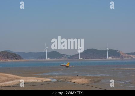Three power generating windmills on shore of small port in Pyeongtaek, South Korea Stock Photo