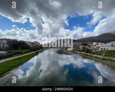 Riverside Illusions: The Sky's Choreography Mirrored in the Water Stock Photo