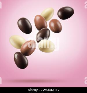 Chocolate easter eggs floating on pink background. Stock Photo