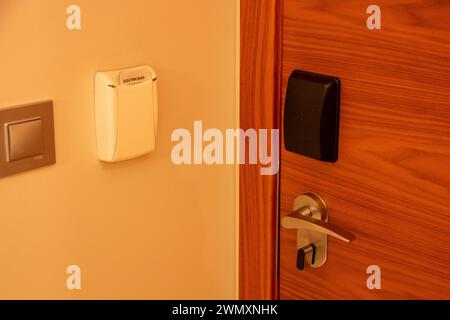 Handle or knob of a wooden door in a hotel with card reader for opening or closing Stock Photo