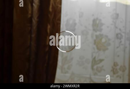 Perfectly round transparent soap bubble on a brown and white background Stock Photo