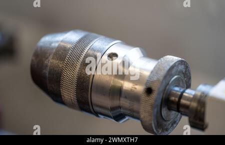 The CNC lathe machine mills slotted spindle parts made of brass and other hard metals via the milling spindle. High-tech metalworking with CNC turning Stock Photo