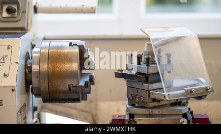 The CNC lathe machine mills slotted spindle parts made of brass and other hard metals via the milling spindle. High-tech metalworking with CNC turning Stock Photo