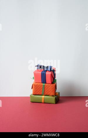 Stack of gift boxes on red desk. gray wall background Stock Photo