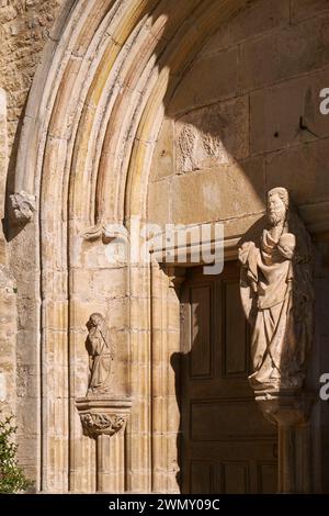 France, Jura, Baume les Messieurs, labelled Les Plus Beaux Villages de France (The Most Beautiful Villages of France), the Saint Pierre Abbey, Romanesque portal of the abbey church, trumeau decorated with a statue of Saint Peter blessing the world with his right hand (15th century), Musician angel in a side niche Stock Photo